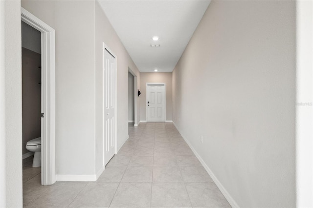 corridor with light tile patterned floors, baseboards, and recessed lighting