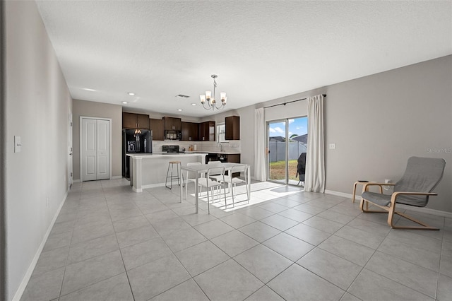 living area with light tile patterned floors, baseboards, recessed lighting, and a notable chandelier