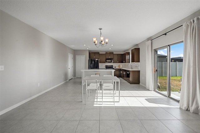 kitchen featuring dark brown cabinets, black appliances, light countertops, tasteful backsplash, and a notable chandelier