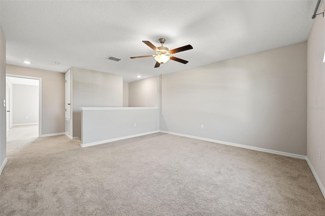 spare room with light colored carpet, a ceiling fan, baseboards, recessed lighting, and visible vents