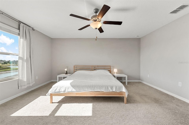 carpeted bedroom with visible vents, baseboards, and ceiling fan