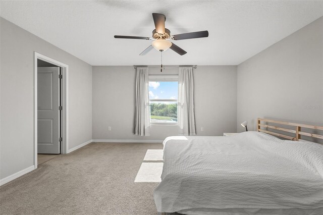 carpeted bedroom featuring baseboards and ceiling fan