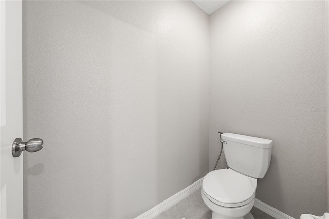 bathroom with toilet and baseboards
