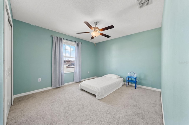 unfurnished bedroom with visible vents, carpet flooring, baseboards, and a ceiling fan