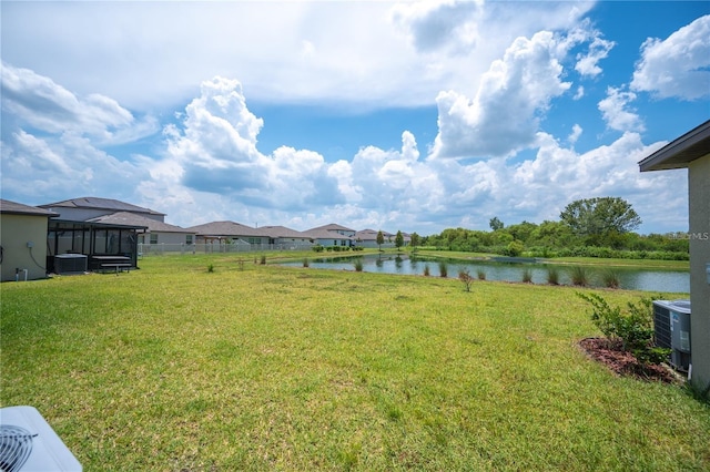view of yard with a water view and central AC