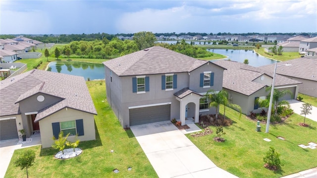 view of front of house featuring a water view, a garage, a residential view, and stucco siding