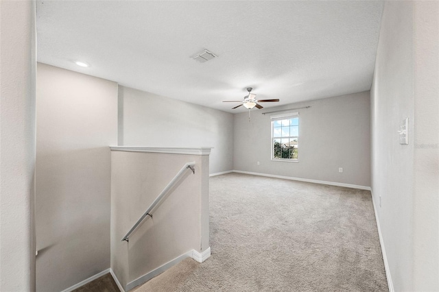 unfurnished room featuring visible vents, baseboards, carpet floors, and ceiling fan