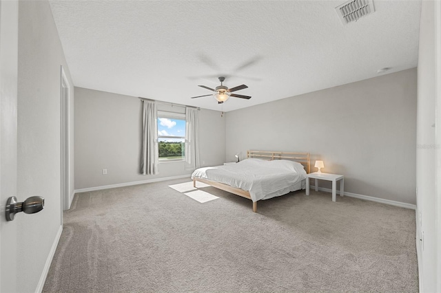 bedroom featuring ceiling fan, carpet floors, a textured ceiling, baseboards, and visible vents
