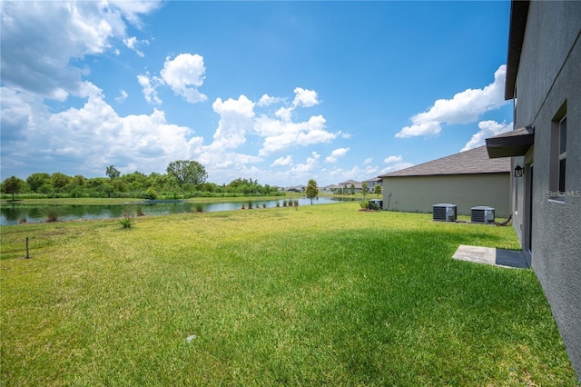 view of yard with a water view and central AC unit