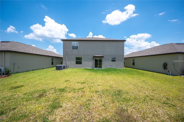 back of property with a lawn, stucco siding, and cooling unit