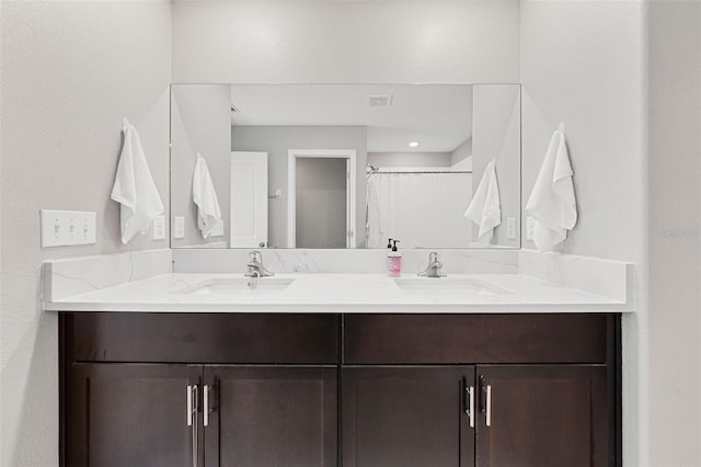 bathroom featuring a sink, a shower with curtain, double vanity, and visible vents