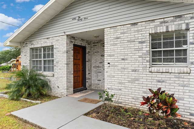 view of exterior entry with brick siding