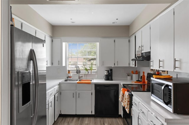 kitchen featuring under cabinet range hood, decorative backsplash, a sink, and black appliances
