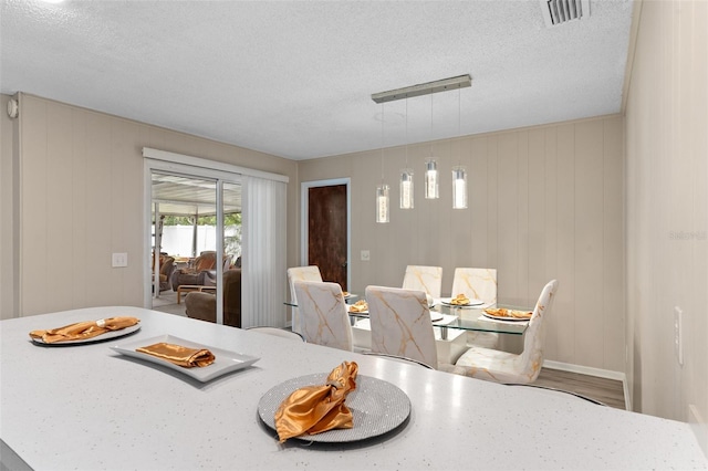dining space featuring visible vents and a textured ceiling