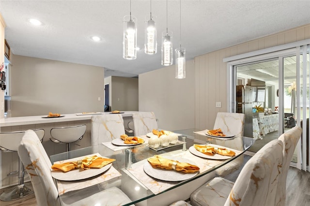 dining space featuring a textured ceiling, wood finished floors, and recessed lighting