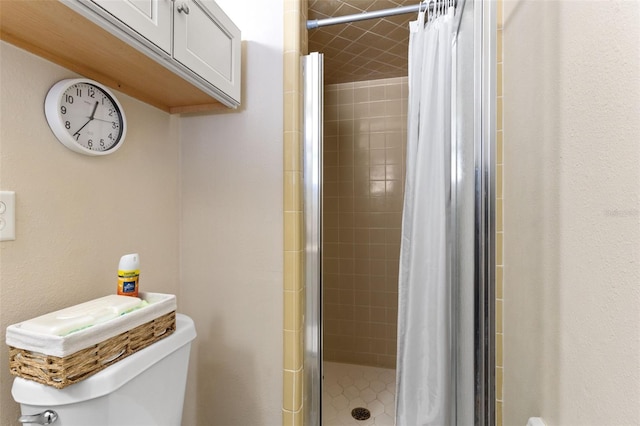 bathroom with toilet and a stall shower