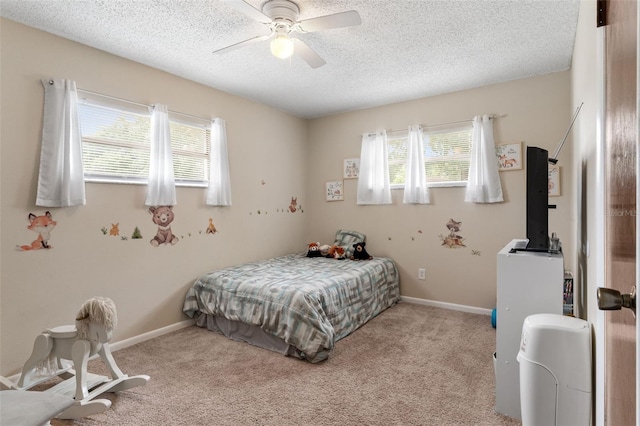 carpeted bedroom featuring ceiling fan, multiple windows, baseboards, and a textured ceiling