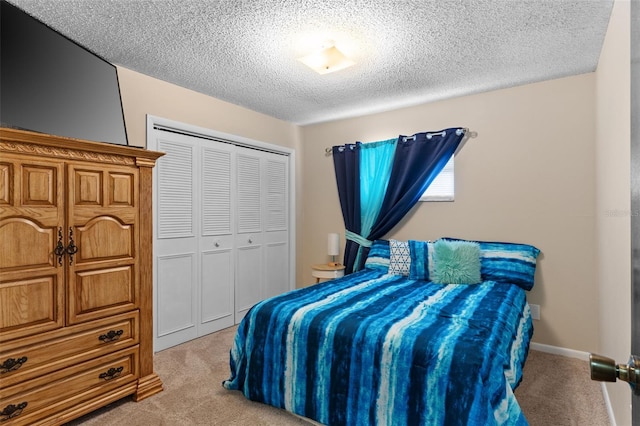 bedroom with a textured ceiling, a closet, and light colored carpet