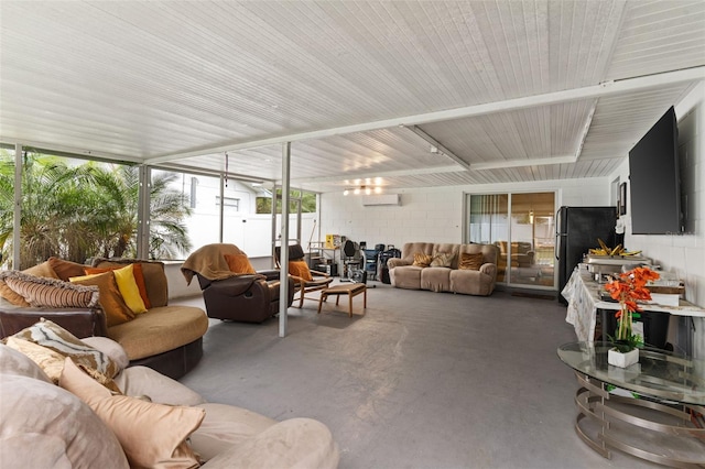 living area featuring a wall mounted air conditioner, concrete floors, and concrete block wall