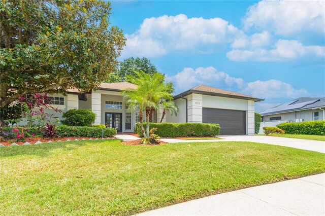 8023 Canyon Lake Cir, Orlando, FL 32835 - view of front of home featuring french doors, driveway, stucco siding, and a front yard