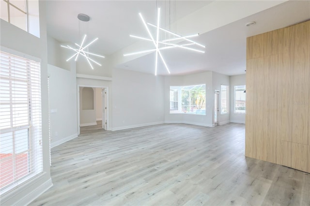 8023 Canyon Lake Cir, Orlando, FL 32835 - unfurnished living room with light wood finished floors, a chandelier, high vaulted ceiling, and baseboards
