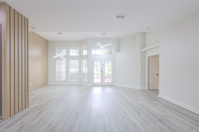 8023 Canyon Lake Cir, Orlando, FL 32835 - unfurnished living room with a chandelier, light wood finished floors, a towering ceiling, and baseboards