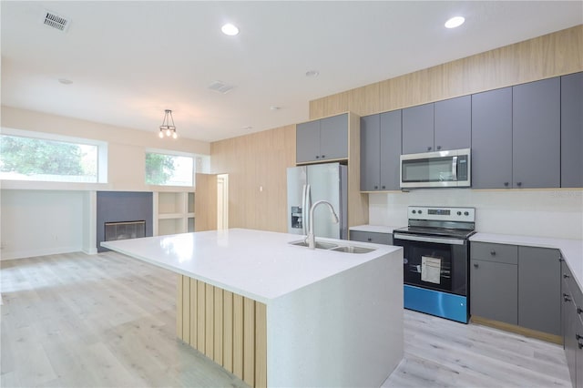 8023 Canyon Lake Cir, Orlando, FL 32835 - kitchen featuring appliances with stainless steel finishes, a sink, gray cabinets, light wood-style flooring, and light countertops