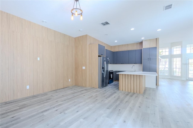 8023 Canyon Lake Cir, Orlando, FL 32835 - kitchen featuring stainless steel refrigerator with ice dispenser, light wood finished floors, an island with sink, open floor plan, and recessed lighting