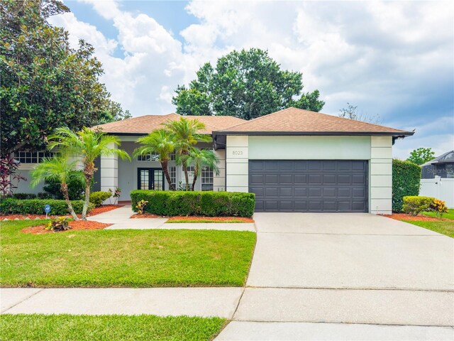 8023 Canyon Lake Cir, Orlando, FL 32835 - view of front of home featuring concrete driveway, a garage, stucco siding, and roof with shingles