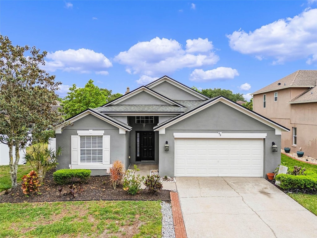 ranch-style house featuring a garage, stucco siding, and concrete driveway