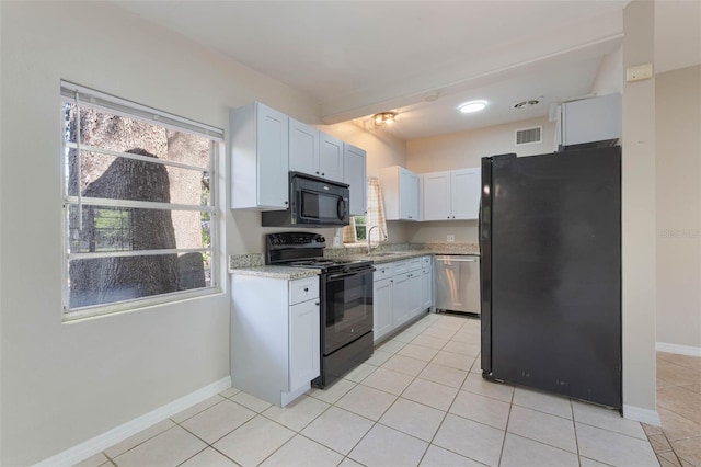 kitchen featuring a sink, baseboards, black appliances, and plenty of natural light