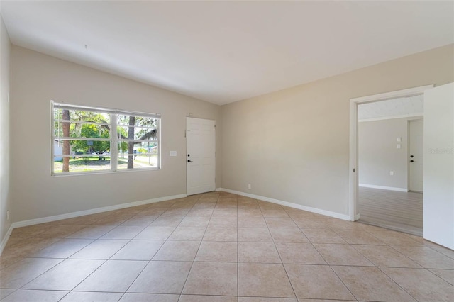 empty room featuring light tile patterned floors and baseboards