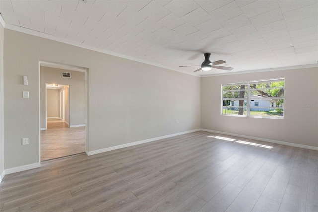 unfurnished room featuring baseboards, ornamental molding, a ceiling fan, visible vents, and wood finished floors