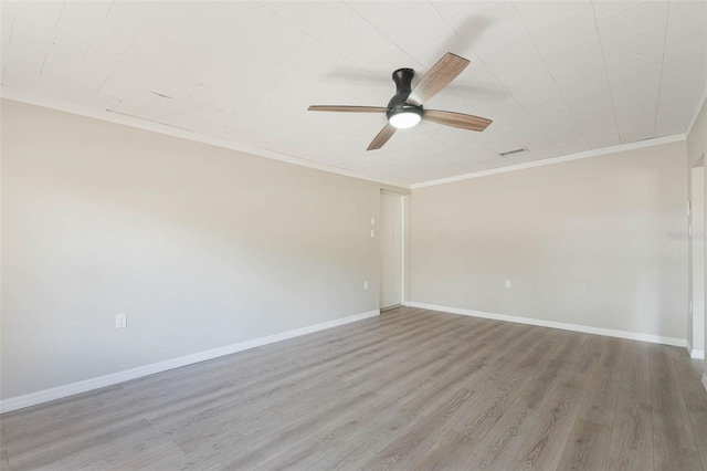 spare room featuring wood finished floors, baseboards, ornamental molding, and ceiling fan