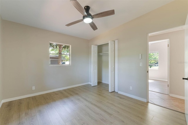 unfurnished bedroom featuring light wood-type flooring, a closet, ceiling fan, and baseboards
