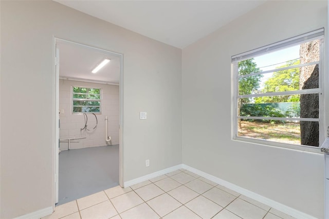 empty room featuring light tile patterned floors and baseboards