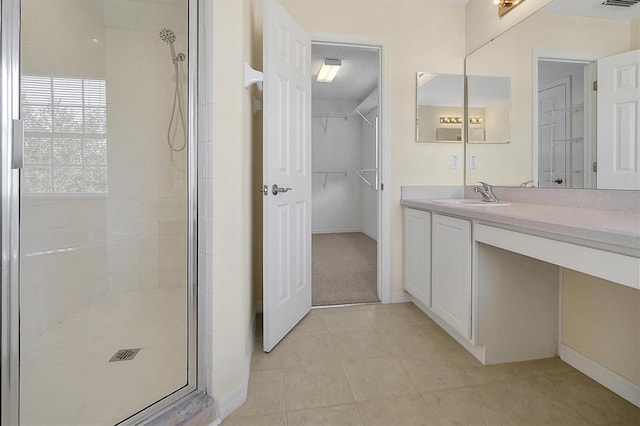 bathroom featuring visible vents, baseboards, vanity, tile patterned floors, and a stall shower