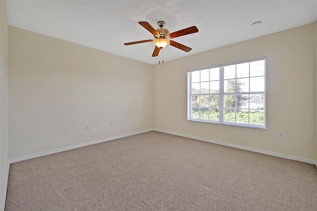 unfurnished room with carpet, baseboards, a ceiling fan, and a textured ceiling