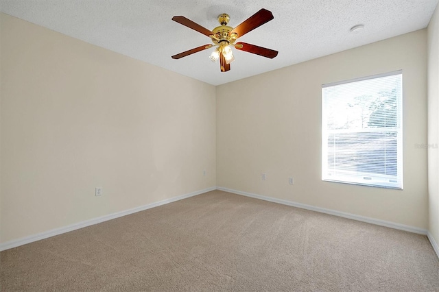 unfurnished room featuring ceiling fan, light colored carpet, baseboards, and a textured ceiling