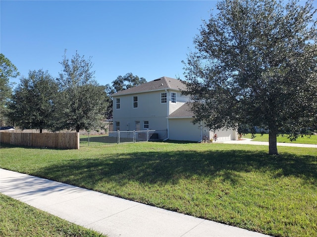 view of home's exterior featuring an attached garage, fence, and a lawn