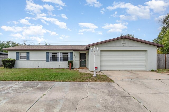 ranch-style home featuring concrete driveway, a front lawn, brick siding, a garage, and fence