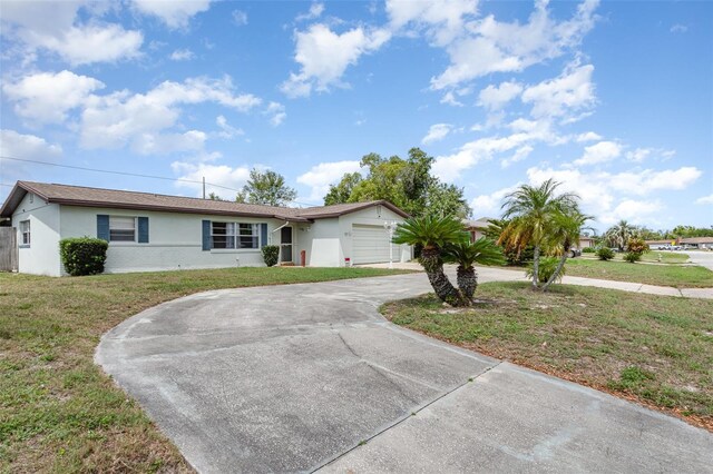 ranch-style house with a front yard, stucco siding, an attached garage, and curved driveway