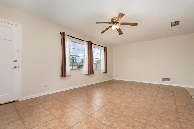 spare room featuring baseboards, a ceiling fan, and visible vents