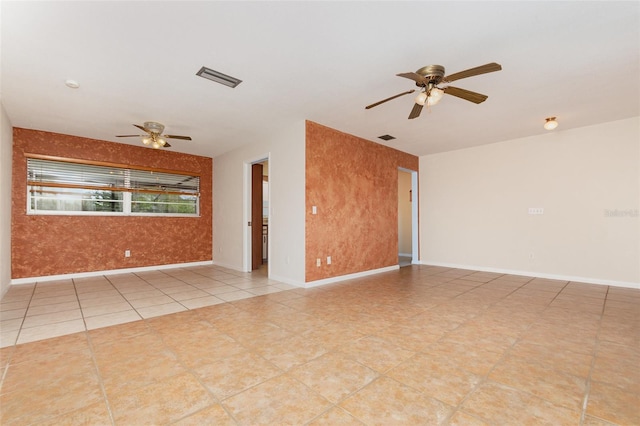 unfurnished room featuring visible vents, ceiling fan, and baseboards