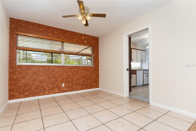 spare room with baseboards, a ceiling fan, and light tile patterned flooring