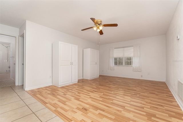 unfurnished room with light wood-style flooring, baseboards, and a ceiling fan