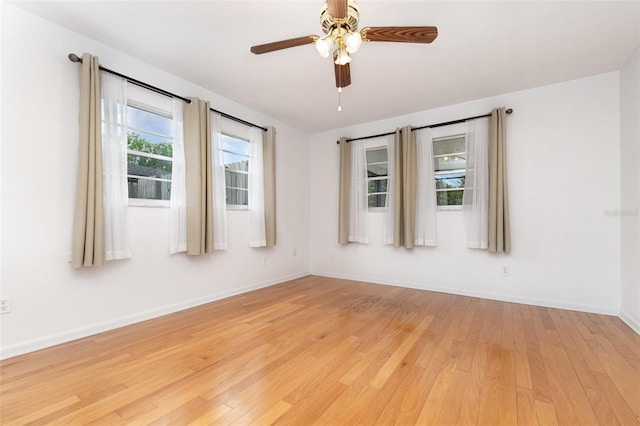 unfurnished room with light wood-type flooring, baseboards, and a ceiling fan
