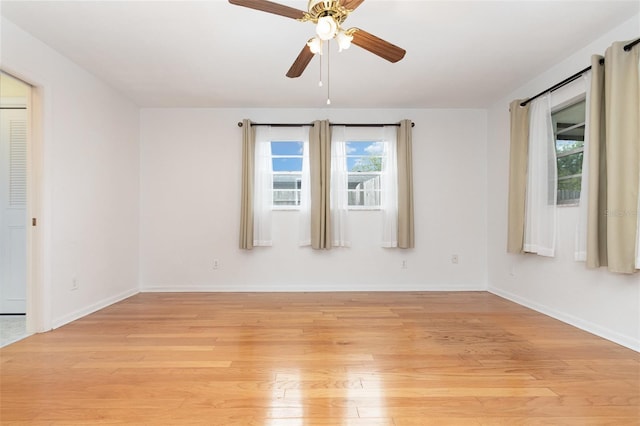 spare room with light wood-style flooring, ceiling fan, and baseboards