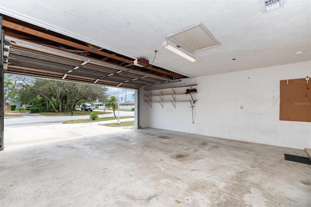 garage featuring a garage door opener and visible vents