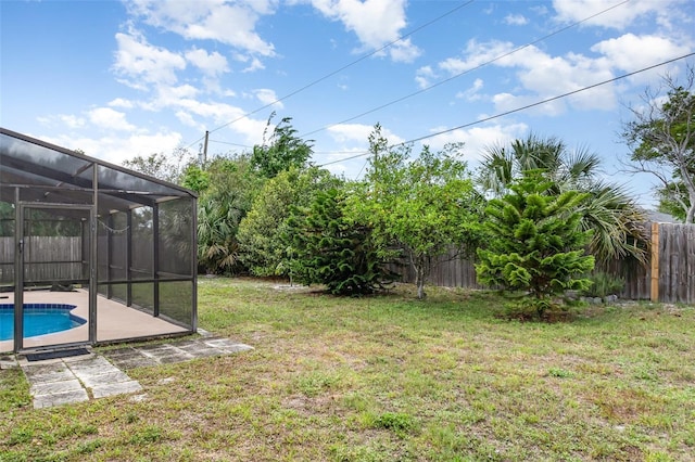 view of yard with a fenced in pool, a fenced backyard, and glass enclosure